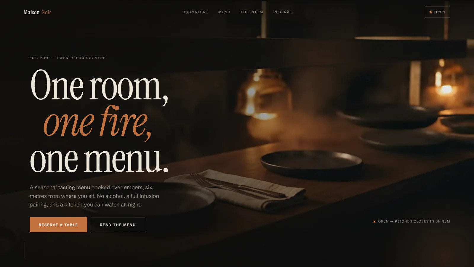 Maison Noir — the site's opening view, “One room, one fire, one menu.”, over a candlelit kitchen pass